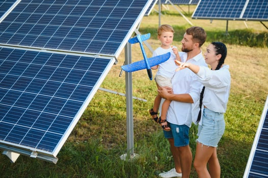 The concept of green energy. Happy family walking and having fun in solar panel field. Green energy. photo