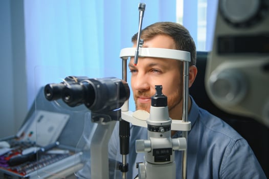Handsome young man is checking the eye vision in modern ophthalmology clinic. Patient in ophthalmology clinic photo