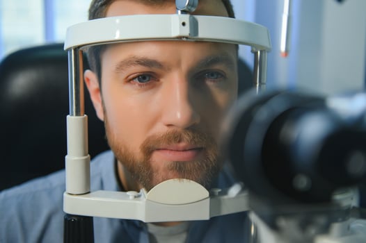 Handsome young man is checking the eye vision in modern ophthalmology clinic. Patient in ophthalmology clinic photo