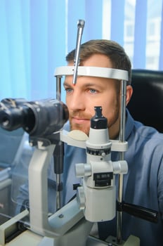 Handsome young man is checking the eye vision in modern ophthalmology clinic. Patient in ophthalmology clinic photo