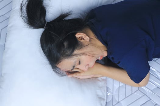 Tired beautiful Asian woman yawning in bed. Bedtime concept photo