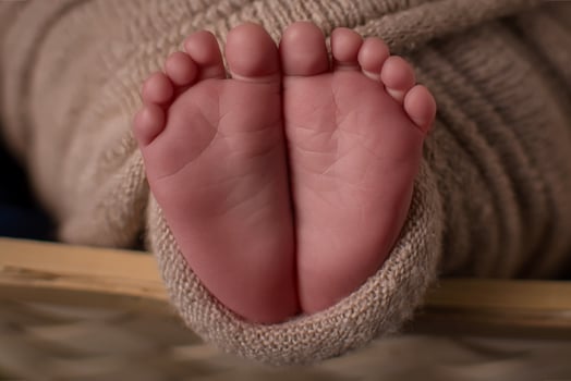 Parent holding in the hands feet of newborn baby. photo