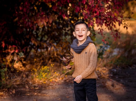 Handsome stylish boy standing in autumn park photo