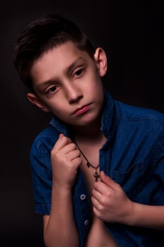 boy posing on a black background . close-up photo