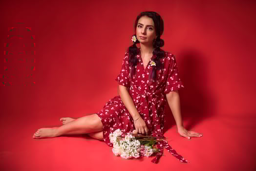 beautiful girl in a red dress on a red background with flowers photo