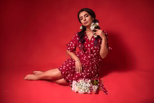 beautiful girl in a red dress on a red background with flowers photo