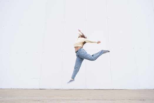 plus size woman wearing casual clothes dancing on white wall background in the street photo