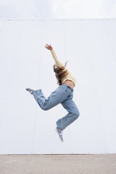 plus size woman wearing casual clothes dancing on white wall background in the street photo