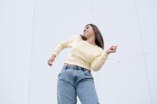 plus size woman wearing casual clothes dancing on white wall background in the street photo