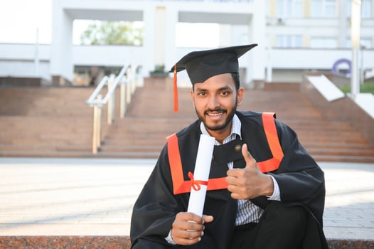 Young indian graduated boy holding his graduation degree convocation ceremony. student graduate posing. photo