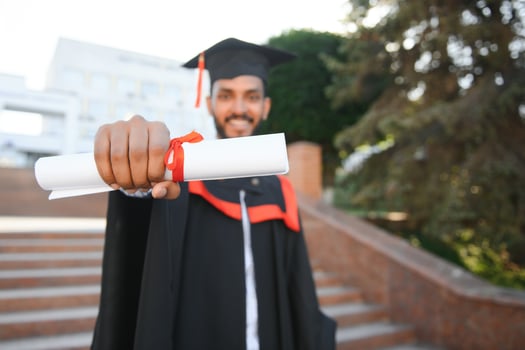 Portrait of indian handsome male graduate in graduation robe. photo