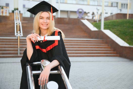 Portrait enthusiastic female college student graduate in cap and gown celebrating, holding diploma. photo