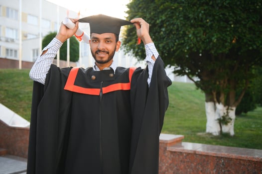 Handsome indian graduate in graduation glow with diploma. photo
