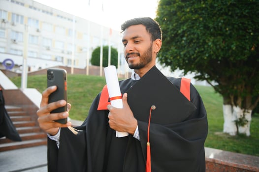 Handsome indian graduate in graduation glow with diploma. photo