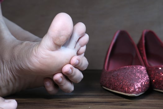 women sitting on floor feeling pain on feet photo
