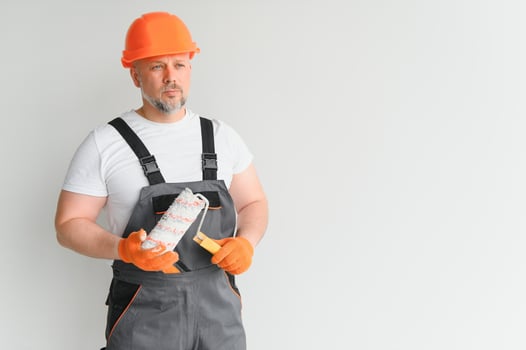 Painter man painting the wall in home, with paint roller and white color paint. Room renovations at house. photo