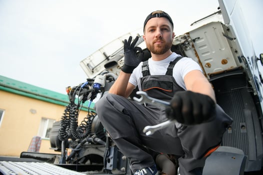 Semi Truck Maintenance. Caucasian Truck Service Worker in His 30s Performing Scheduled Recall Maintenance. photo