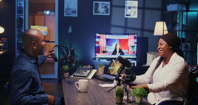 Content creators arriving in studio, ready to use high tech microphone for online show on livestreaming channel. Man and woman starting podcasting session with professional streaming sound gear photo