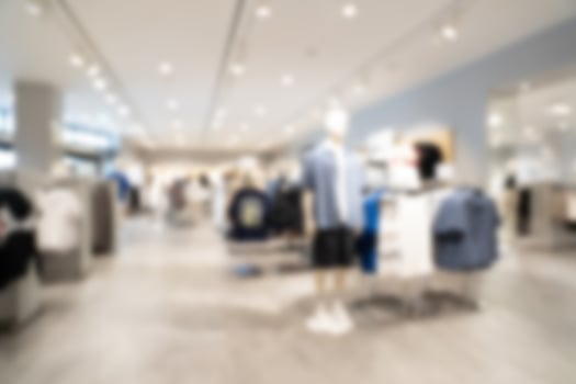 Abstract blur clothing boutique display interior of shopping mall background. blurred image background with clothing store. photo