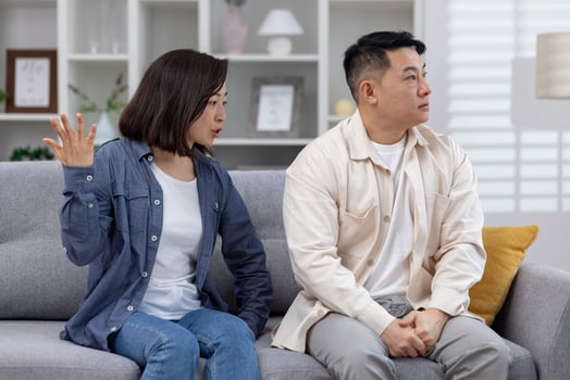 Man and woman having a serious discussion at home, portraying conflict and relationship issues. photo