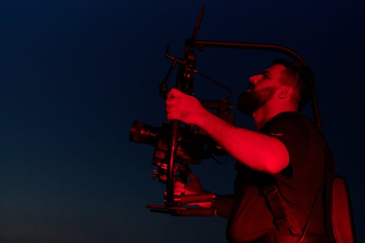 Nighttime Capture. Professional Videographer Films Athletes Running in Red-Lit Darkness photo