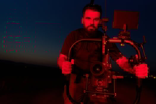 Nighttime Capture. Professional Videographer Films Athletes Running in Red-Lit Darkness photo