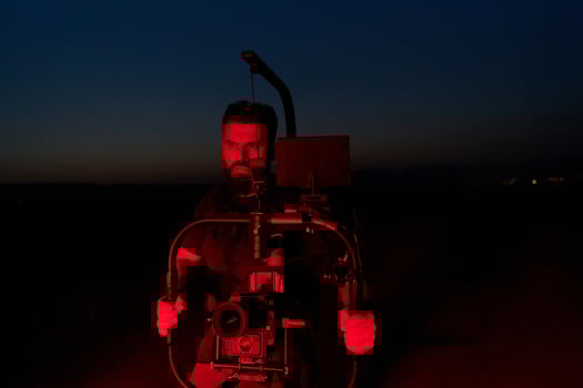 Nighttime Capture. Professional Videographer Films Athletes Running in Red-Lit Darkness photo
