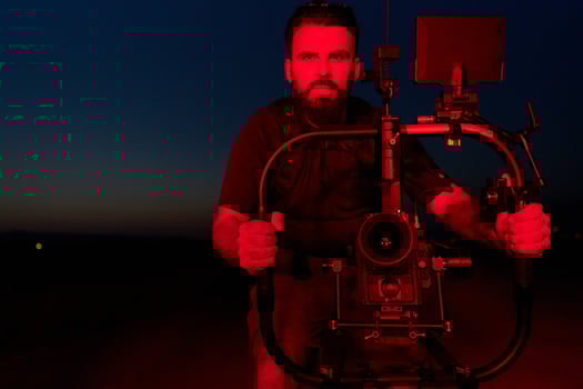 Nighttime Capture. Professional Videographer Films Athletes Running in Red-Lit Darkness photo