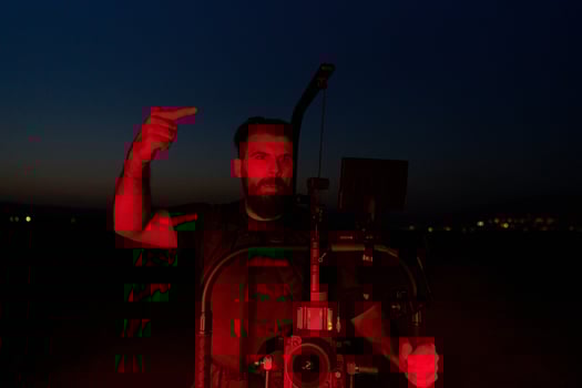 Nighttime Capture. Professional Videographer Films Athletes Running in Red-Lit Darkness photo