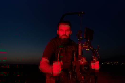 Nighttime Capture. Professional Videographer Films Athletes Running in Red-Lit Darkness photo