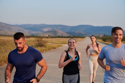 A group of friends maintains a healthy lifestyle by running outdoors on a sunny day, bonding over fitness and enjoying the energizing effects of exercise and nature photo