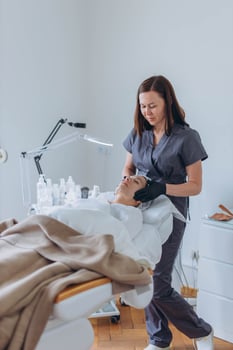 cosmetologist and client in a beauty salon doing procedures. Using a face mask photo