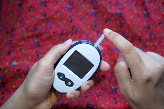 young women test blood sugar for diabetes, close up photo