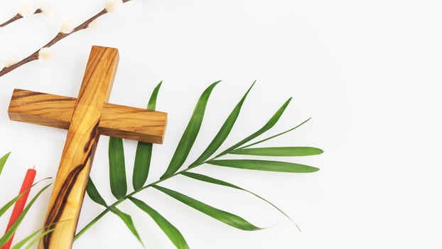 Wooden crucifixion, palm leaf, willow branch and red church candle photo