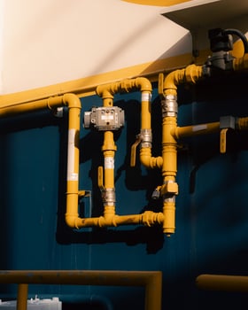 A yellow pipe against a blue wall photo