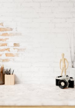 A space for displaying products on a white marble tabletop against a white brick wall. photo