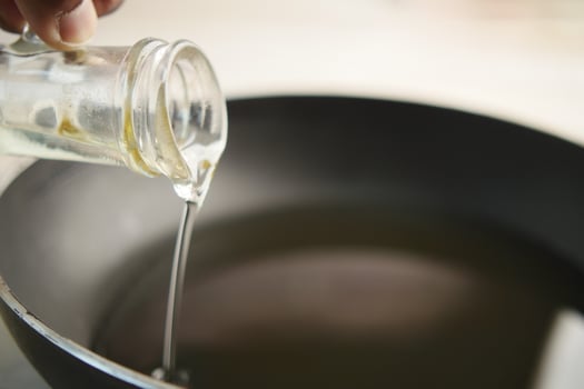Pouring vegetable oil into frying pan. photo