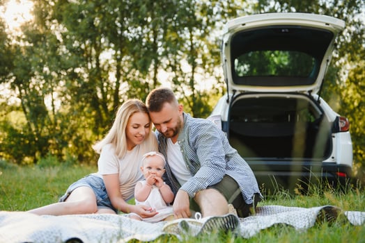Family in a forest. People by the car. Sunset background. photo