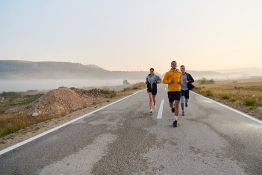 A group of friends, athletes, and joggers embrace the early morning hours as they run through the misty dawn, energized by the rising sun and surrounded by the tranquil beauty of nature photo