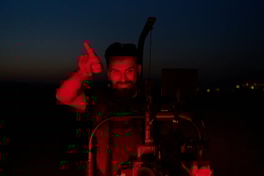 Nighttime Capture. Professional Videographer Films Athletes Running in Red-Lit Darkness photo