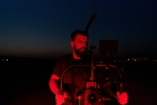Nighttime Capture. Professional Videographer Films Athletes Running in Red-Lit Darkness photo