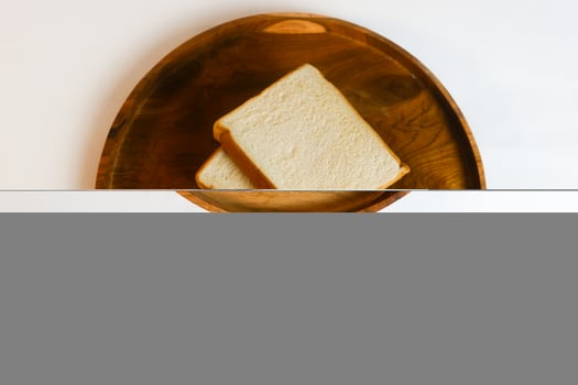 photography of white bread on a wooden coaster with a white background photo
