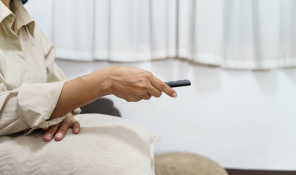 Elderly woman Watching smart TV and using remote controller Hand holding television audio remote control Middle age Asian woman movie Television series spending time at home photo