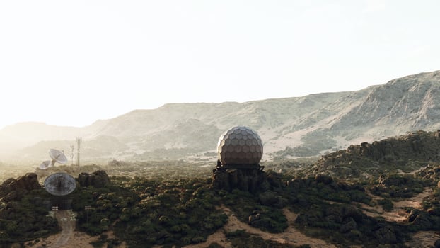A mountain range with a satellite dish in the foreground photo