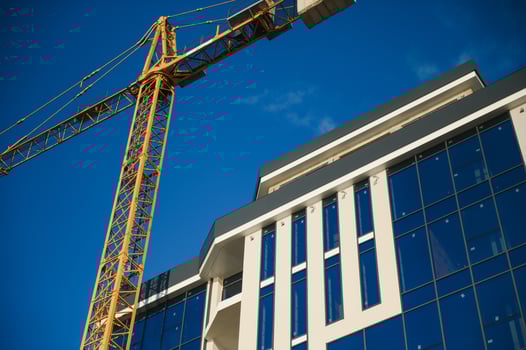 Construction cranes are standing near building houses photo
