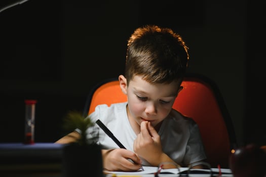 boy doing homework at home in evening photo