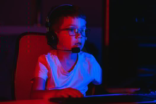 Little boy playing game in the dark room photo