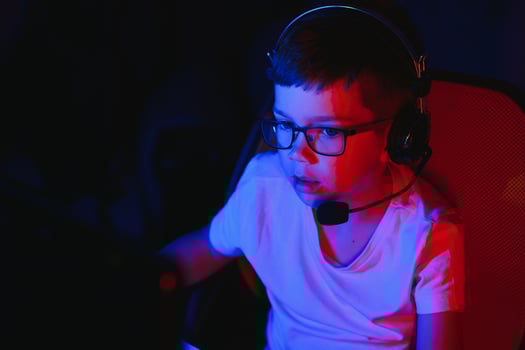 Little boy playing game in the dark room photo