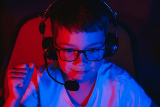 Little boy playing game in the dark room photo