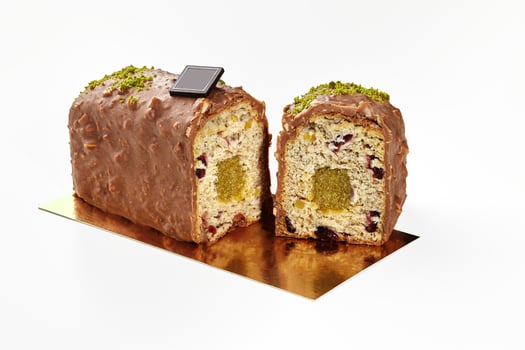 Sliced chocolate glazed loaf cake with fruit jelly, dried berries and nuts photo